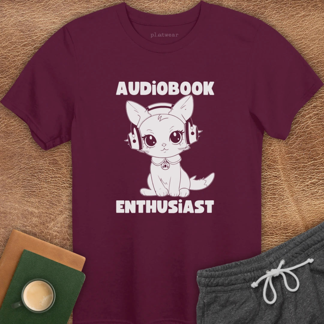 Black crew neck t-shirt with text 'AUDIOPBOOK ENTHUSIAST' and an illustration of a cat wearing headphones.