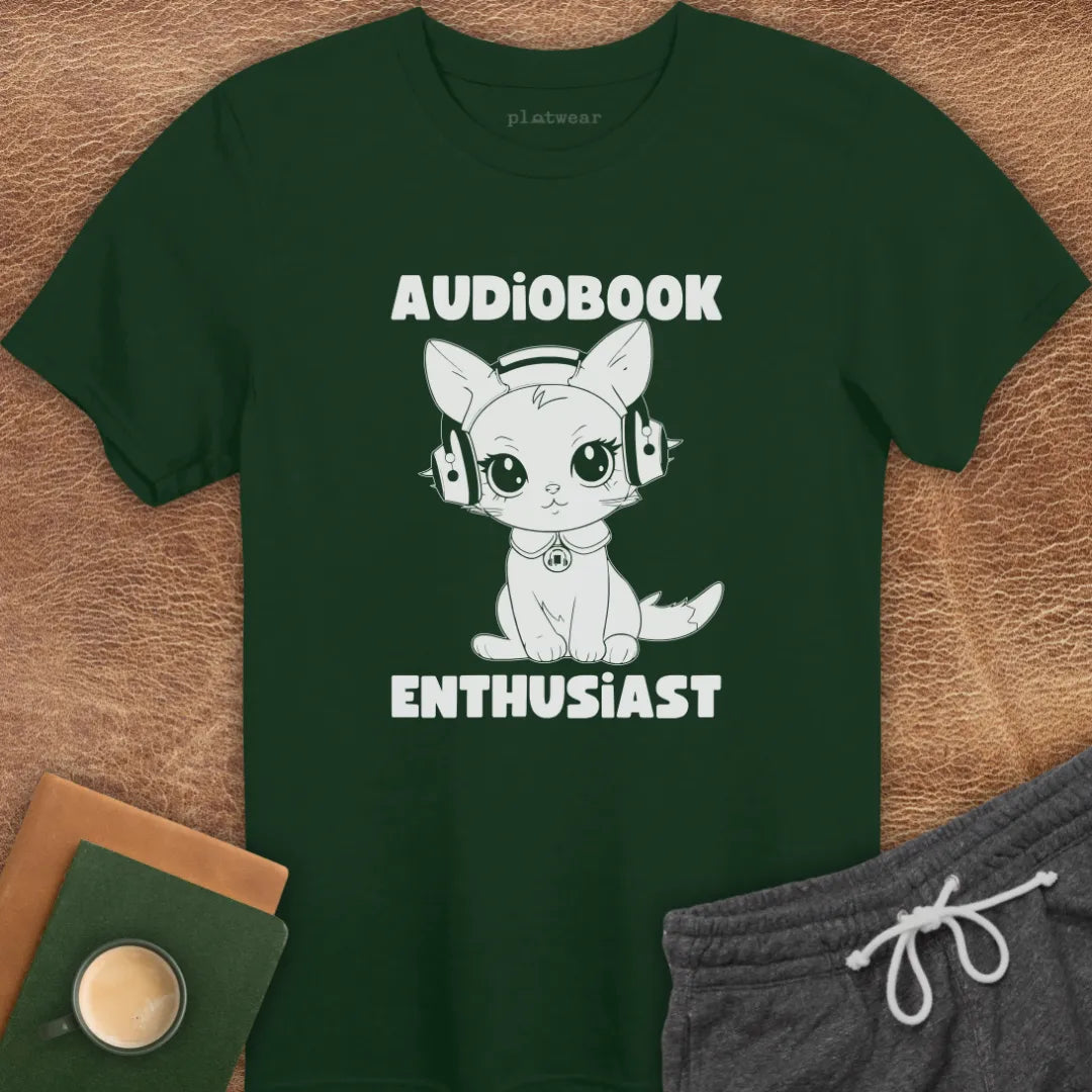 Green t-shirt with cartoon cat and 'Audiobook Enthusiast' text on wooden surface.