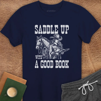 A navy blue crew neck t-shirt with a graphic print of a person on a horse and the phrase 'SADDLE UP WITH A GOOD BOOK'.